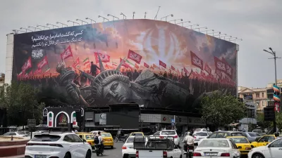 A billboard depicting a fallen Statue of Liberty and crowds carrying Iranian and Shiite flags overlooks Revolution Square as traffic drives by in Tehran, Iran, Monday, Aug. 3, 2026. (AP Photo/Vahid Salemi)