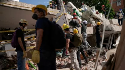 People clean up debris, as search and rescue operations are under way at the site of a destroyed Cantabria building, following the earthquake in Cali, Colombia, August 13, 2026. REUTERS/Sergio Acero