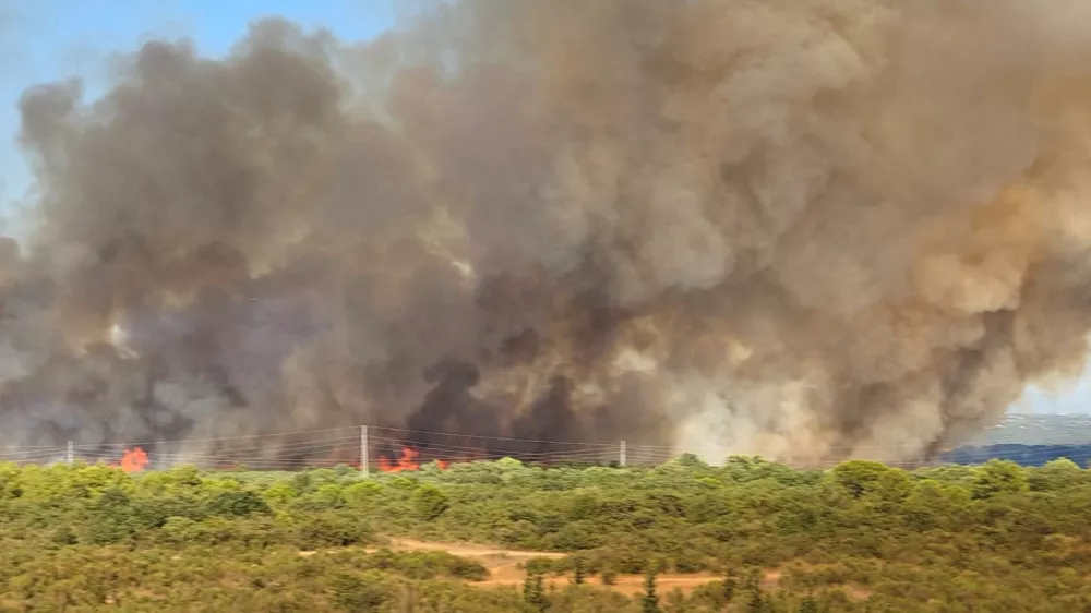 Smoke from a wildfire rises in Zadar, Croatia, August 14, 2026, in this screen grab obtained from a social media video. DOMINIK BRKLJACA/via REUTERS THIS IMAGE HAS BEEN SUPPLIED BY A THIRD PARTY. MANDATORY CREDIT. NO RESALES. NO ARCHIVES. Verification: -Buildings, terrain and roads that matched the archive and satellite imagery of the area -Coordinates: 44.162936, 15.227675 -Original file metadata -Croatian Fire Service reports of the fire