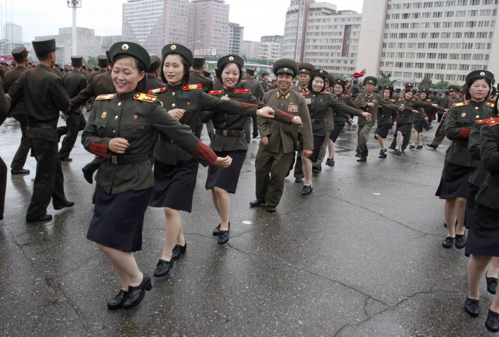 North Korean soldiers dance in the plazas of Pyongyang on Wednesday, July 18, 2012, after North Korea announced that leader Kim Jong Un was granted the title of marshal, a move that cements his status at the top of the authoritarian nation's military as he makes key changes to the 1.2 million-man force. The decision to award the top title to Kim, who already serves as supreme commander of the Korean People's Army, was made Tuesday by the nation's military, government and political leadership, state media said in a special bulletin. (AP Photo/Kim Kwang Hyon)