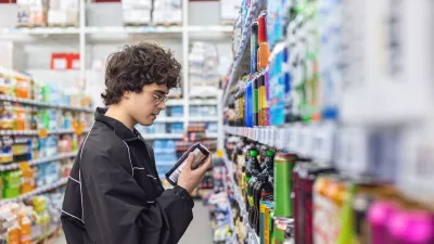 Adolsent boy reading beverage label while shopping in supermarket. unhealthy beverage habits and health risk