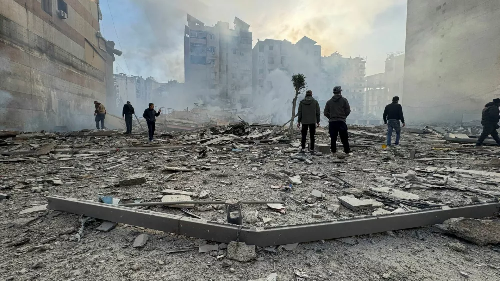 People stand on the rubble of a damaged building after an Israeli strike on Beirut's southern suburbs, following renewed hostilities between Hezbollah and Israel amid the U.S.-Israeli conflict with Iran, in Beirut, Lebanon, March 6, 2026. Picture taken with a mobile phone. REUTERS/Stringer