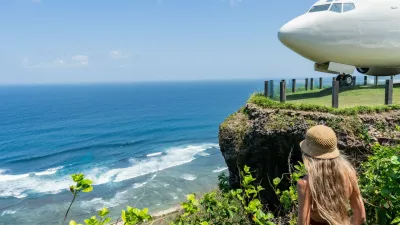 Blonde tourist admiring repurposed boeing 737 airplane on a cliff overlooking the indian ocean in bali,Image: 1001085464, License: Royalty-free, Restrictions:, Model Release: yes