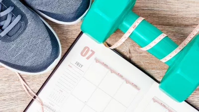 Calendar plan with green dumbbell and sneakers on wooden background. Workout plan concept. / Foto: Gam1983 Getty Images