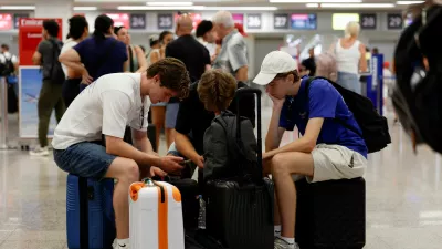 Passengers sit on their luggage in the check-in hall, a day after an ash cloud from Sicily's Mount Etna volcano drifted over Malta, forcing the cancellation of some flights to and from the Mediterranean island at the height of the tourism season, at Malta International Airport in Gudja, Malta, August 12, 2026. REUTERS/Darrin Zammit Lupi