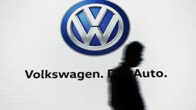 FILE PHOTO: A man walks past a screen displaying a logo of Volkswagen at an event in New Delhi, India, June 23, 2015. REUTERS/Anindito Mukherjee/File Photo