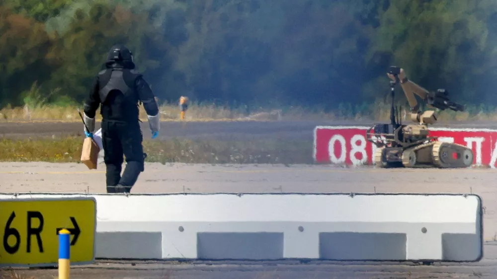 FILE PHOTO: A police officer in protective clothing walks next to an explosive-disarming robot (EOD) at Leipzig/Halle Airport in Schkeuditz, Germany, August 5, 2026, after the police said explosives experts examined a drone found near a runway, and after a DHL cargo aircraft hit an unknown object as it was climbing away from the airport overnight, prompting an unscheduled landing in Hanover, according to a source familiar with the incident. REUTERS/Axel Schmidt/File Photo