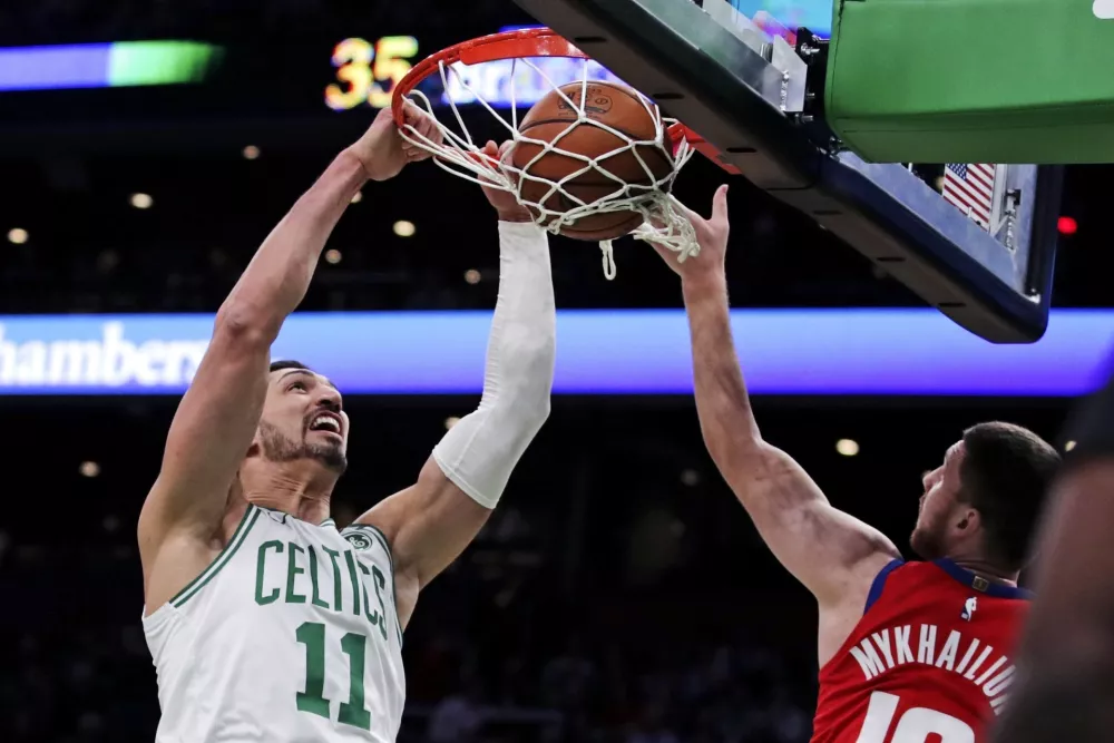 Boston Celtics center Enes Kanter (11) dunks next to Detroit Pistons guard Sviatoslav Mykhailiuk (19) during the first half of an NBA basketball game in Boston, Wednesday, Jan. 15, 2020. (AP Photo/Charles Krupa) / Foto: Charles Krupa