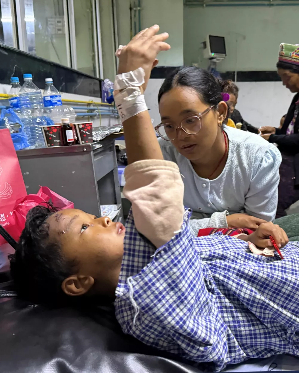 Zoyal Ghale, 8, who was airlifted from Rasuwa after being injured in the deadly flash floods and mudslide, speaks with his mother Matti Maya Tamang, 28, two days after they were separated following the floods, inside a hospital in Kathmandu, Nepal, August 28, 2026. Picture taken with a mobile phone. REUTERS/Ranup Shrestha