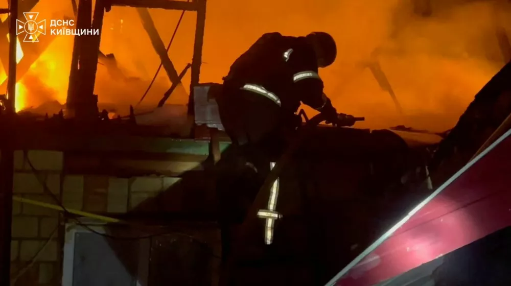 A firefighter works at a site after a Russian drone strike on a Kyiv-area warehouse sparked a detonation, according to officials, in a location given as Myla, Kyiv Region, Ukraine, in this screen grab obtained from a handout video released August 29, 2026. State Emergency Service Of Ukraine/Handout via REUTERS  THIS IMAGE HAS BEEN SUPPLIED BY A THIRD PARTY. MANDATORY CREDIT. WATERMARK FROM SOURCE. VERIFICATION: -Buildings, steeple and car park matched satellite and archive imagery -Date could not be verified, but statement from Kyiv governor on August 29 said at least 27 people were killed in the strike on the Kyiv area