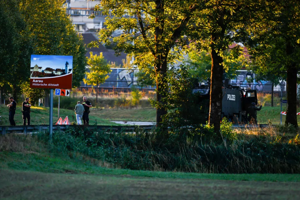 Police officers block a street near the Schachen horse racing track in Aarau following a shooting at a rave event near Aarau, Switzerland Sunday, Aug. 30, 2026. (Michael Buholzer/Keystone via AP)