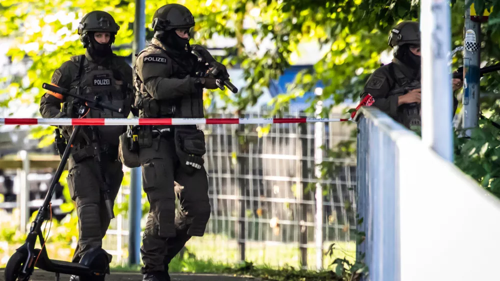 Armed police officers patrol near the Schachen horse racing track in Aarau following a shooting during a rave event near Aarau, Switzerland, Sunday, Aug. 30, 2026. (Michael Buholzer/Keystone via AP)