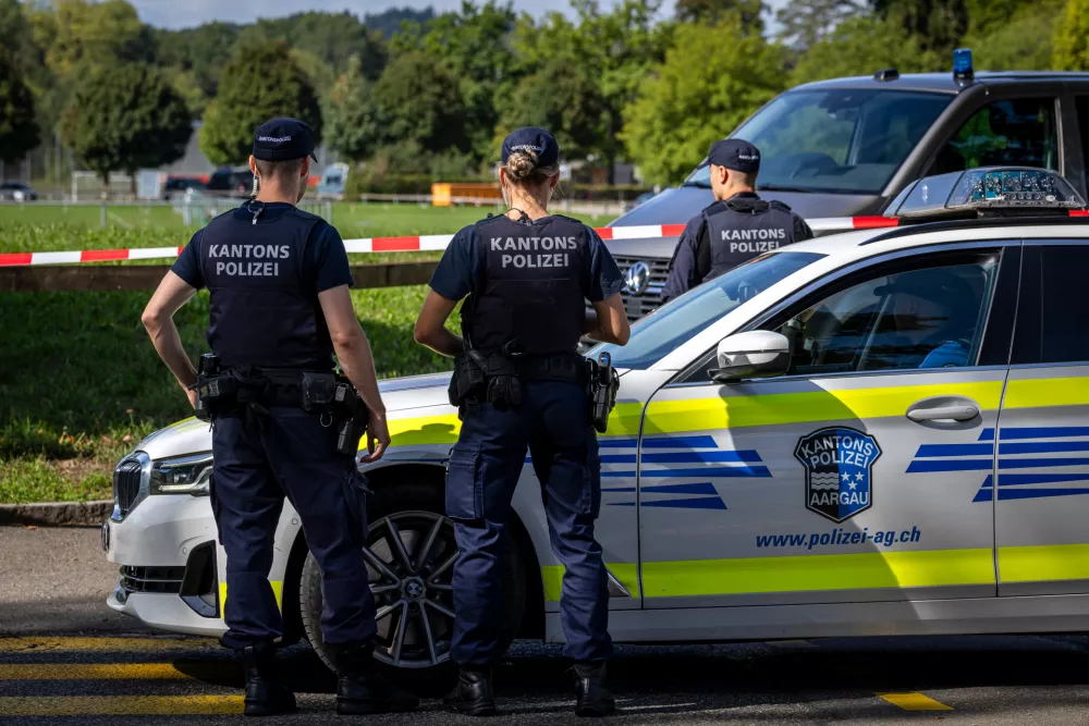 Police officers secure the area around the Schachen horse racing track following a shooting at a rave, in Aarau, Switzerland, Sunday Aug. 30, 2026. (Michael Buholzer/Keystone via AP)