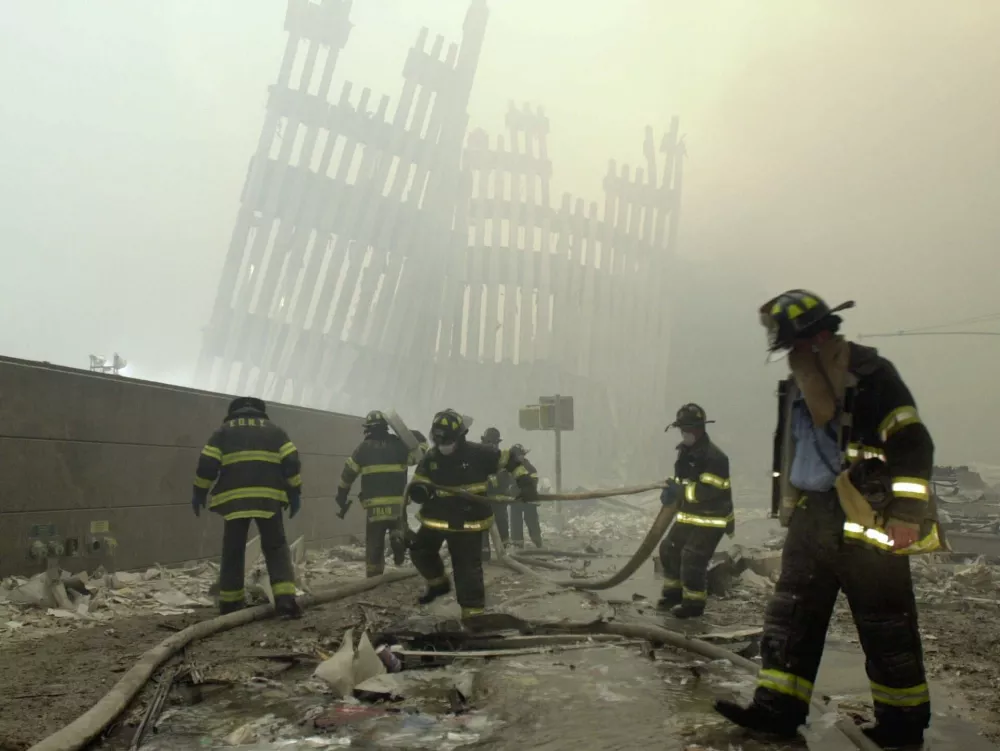 THEN-- With the skeleton of the World Trade Center twin towers in the background, New York City firefighters work amid debris on Cortlandt St. after the terrorist attacks of Tuesday, Sept. 11, 2001. (AP Photo/Mark Lennihan) / Foto: Mark Lennihan