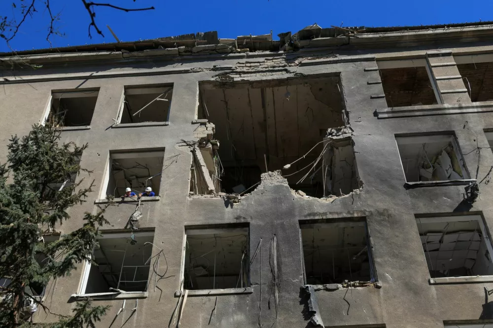 Workers remove a broken air conditioner from a building of a business centre hit by a Russian drone strike, amid Russia's attack on Ukraine, in Odesa, Ukraine September 2, 2026. REUTERS/Nina Liashonok