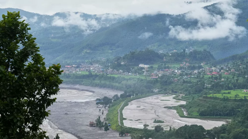 Structures partially submerged in mud brought in by flash floods stand at the banks of the Trishuli river in Nepal's Nuwakot district, Thursday, Sept. 3, 2026. (AP Photo/Rajesh Kumar Singh)
