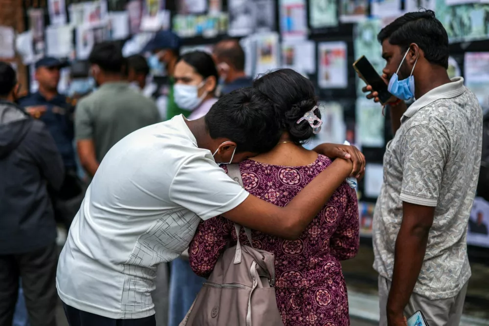 FILE PHOTO: People react in front of a wall displaying photographs of missing people outside Tribhuvan University Teaching Hospital following the deadly flash floods and mudslide, in Kathmandu, Nepal, September 2, 2026. REUTERS/Athit Perawongmetha/File Photo