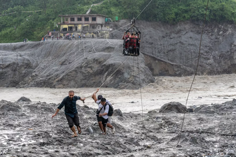 Residents pull a newly installed zipline to help people commute across the Trishuli river in the aftermath of flash floods at Bidur in Nepal's Nuwakot district, Nepal, Wednesday, Sept. 2, 2026. (AP Photo/Rajesh Kumar Singh)