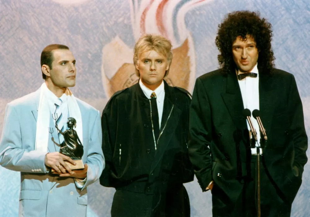 Člani britanske rock skupine Queen, (od leve proti desni) Freddie Mercury, Roger Taylor in Brian May na podelitvi nagrad BRIT leta 1990. Foto: profimedia