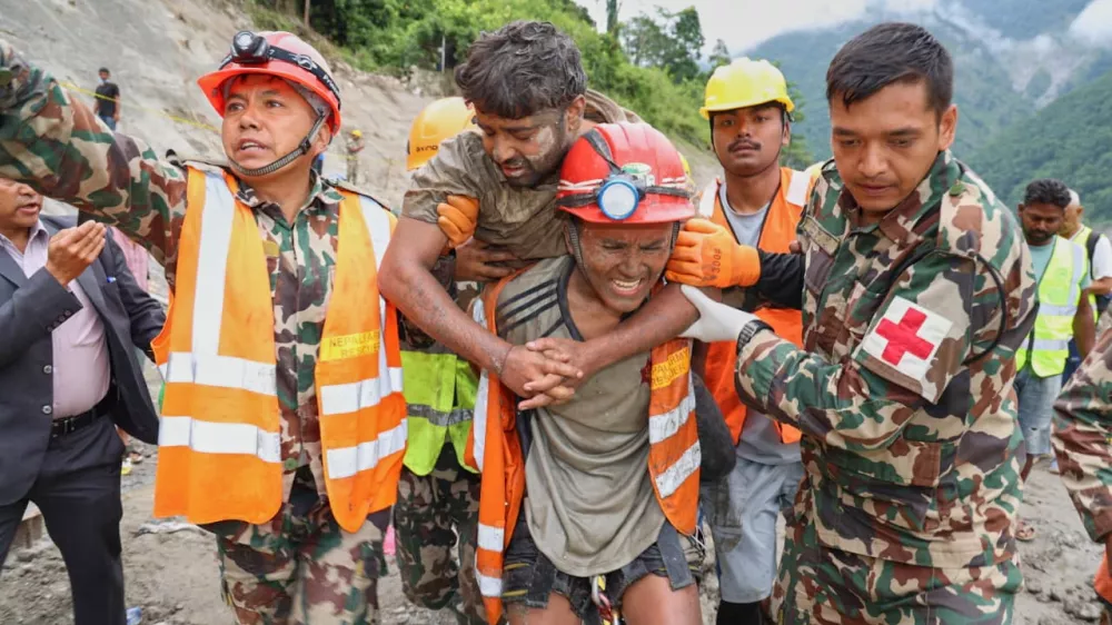 In this photo provided by the Nepal Army, soldiers rescue a worker alive from a tunnel during an ongoing operation at the Trishuli-3A hydropower project in Nepal's Rasuwa district, Friday, Sept. 4, 2026. (Nepal Army via AP)
