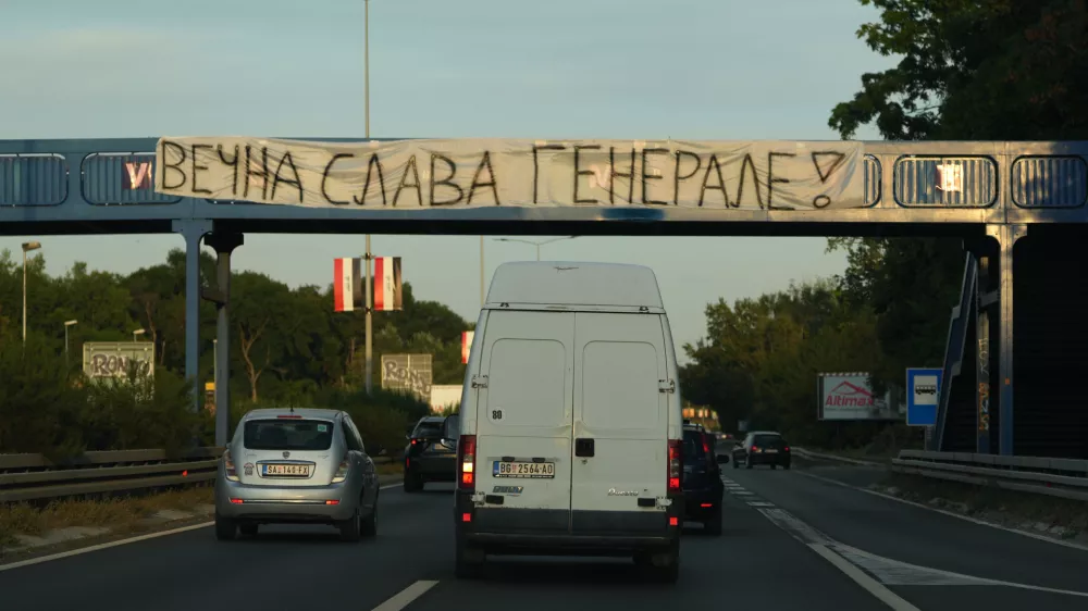 Cars pass under a pedestrian bridge with a banner on it reading: "Eternal glory, General! (former Bosnian Serb wartime general Ratko Mladic)" in Belgrade, Serbia, Thursday, Sept. 3, 2026. (AP Photo/Darko Vojinovic)