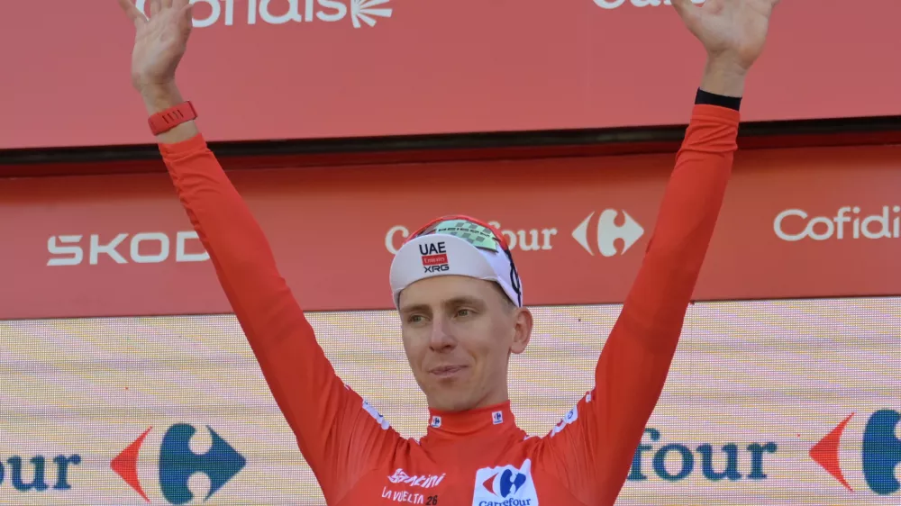 Slovenia's Tadej Pogacar, wearing the overall leader's red jersey celebrates on the podium after the second stage of the La Vuelta cycling race, with start in Monaco and finish in Manosque, France, Sunday, Aug. 23, 2026. (AP Photo/Philippe Magoni)