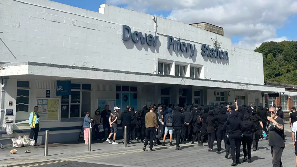 Protesters gather at Dover Priory train station after black-clad and masked demonstrators blocked roads during a protest, in Dover, England, Saturday, Sept. 5, 2026. (Oscar Rihll/PA via AP)