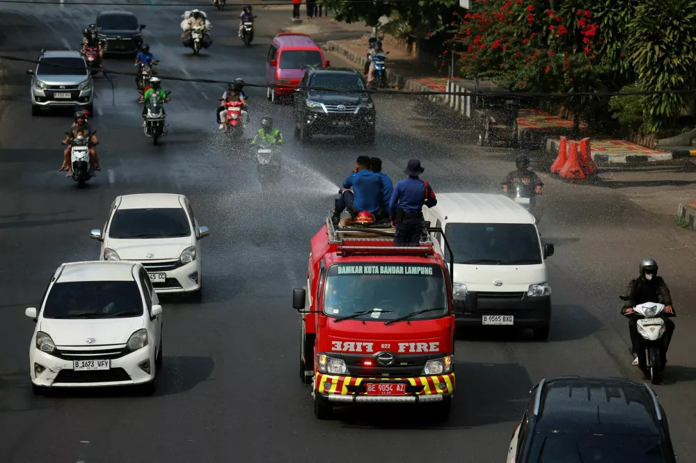 Firefighters spray water to clear volcanic ash following the Mount Anak Krakatau volcano eruption, in Bandar Lampung, Lampung province, Indonesia, September 6, 2026. REUTERS/Stringer   TPX IMAGES OF THE DAY