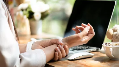 Closeup woman holding her wrist pain from using computer. Office syndrome hand pain by occupational disease.