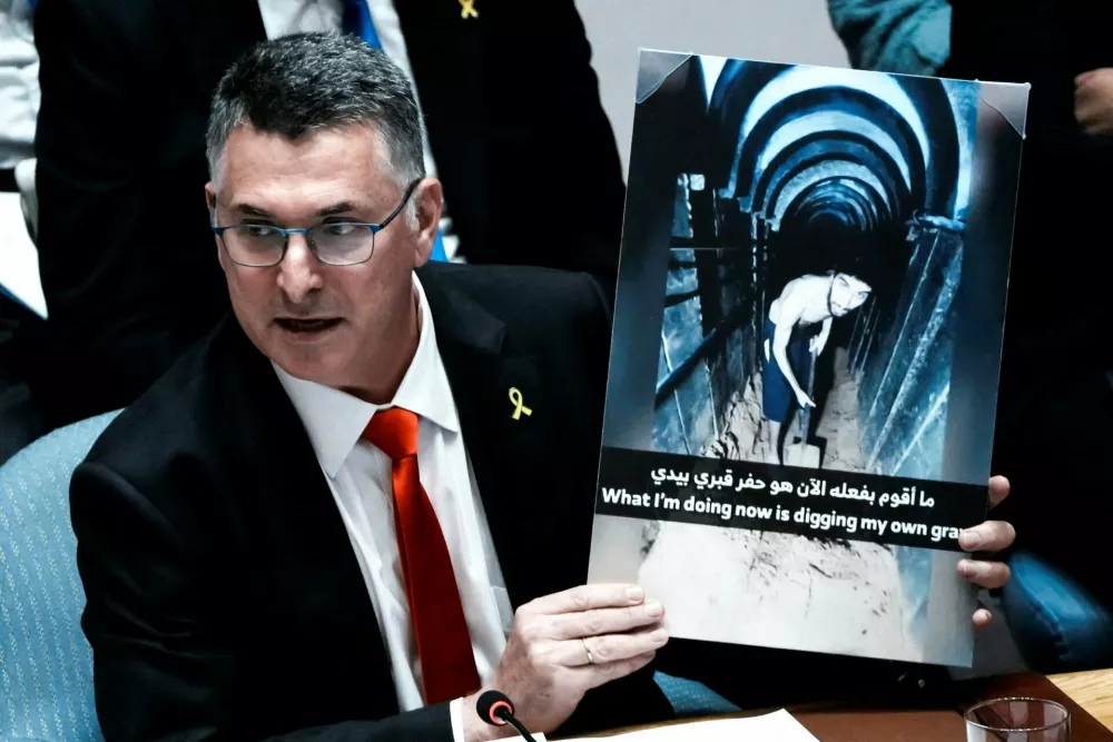 Israeli Foreign Minister Gideon Saar shows a picture of a hostage as he speaks to delegates during a Security Council meeting at U.N. headquarters in New York City, U.S., August 5, 2025. REUTERS/Eduardo Munoz  TPX IMAGES OF THE DAY