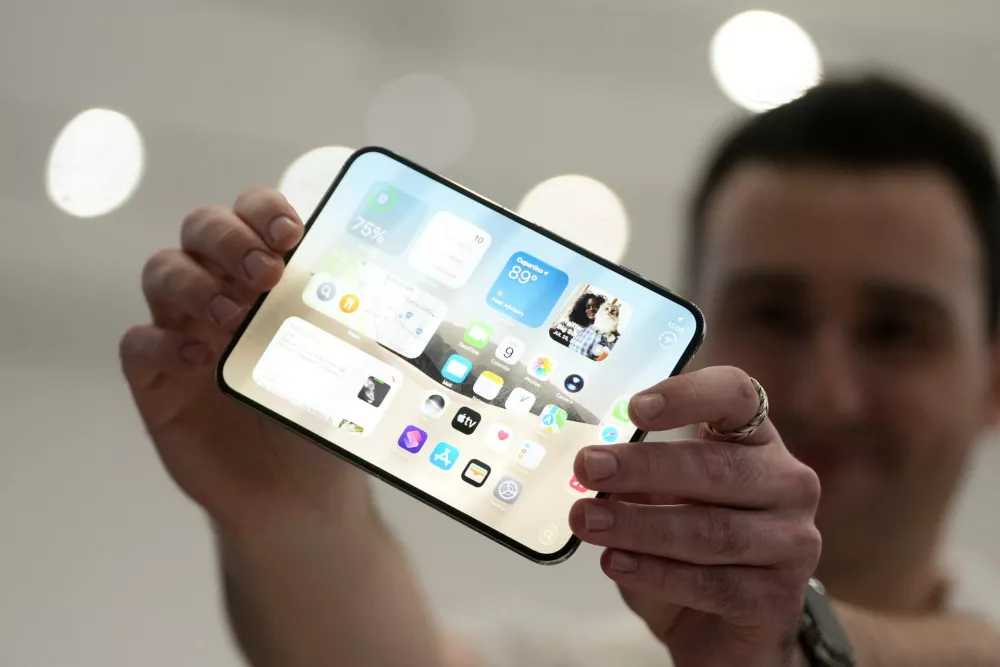 An attendee holds up an iPhone Duo during an announcement of new products on Wednesday, Sept. 9, 2026, on the Apple campus in Cupertino, Calif. (AP Photo/Jeff Chiu)