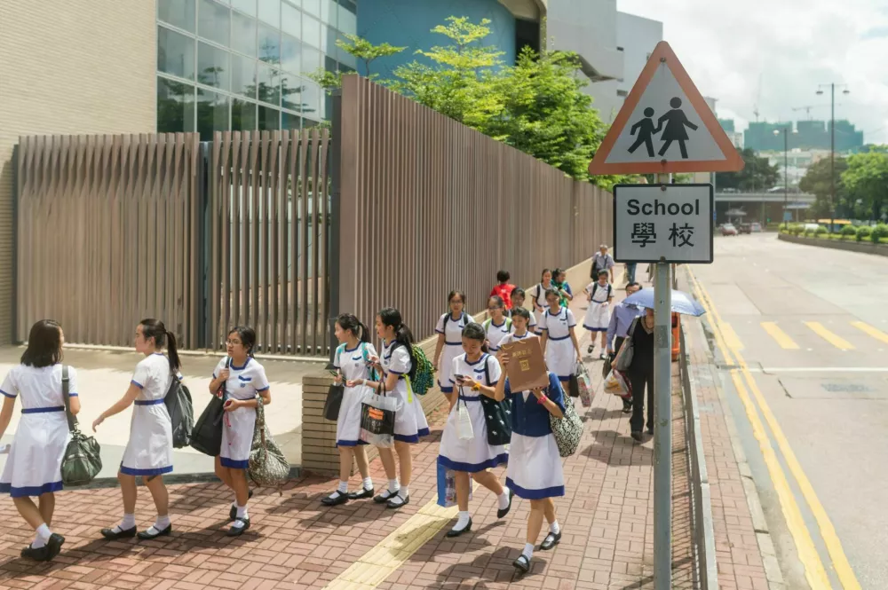 Hongkong, Сhina - July 11, 2014: Unidentified students walking side of the road in July 11 2014,Hong Kong, China.