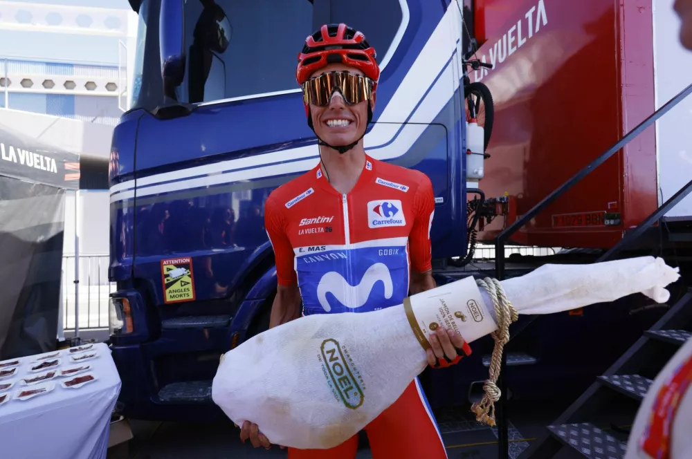 Cycling - Vuelta a Espana - Stage 21 - Granada to Granada - Granada, Spain - September 13, 2026 Movistar Team's Enric Mas wearing the red jersey poses with a leg of jamon before the start of stage 21 REUTERS/Marcelo Del Pozo