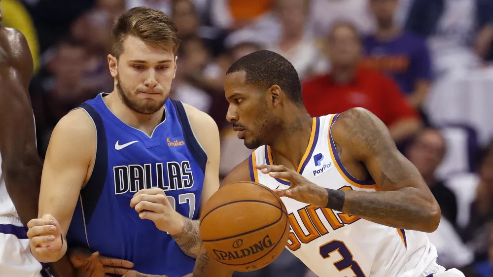 Phoenix Suns forward Trevor Ariza (3) dries past Dallas Mavericks guard Luka Doncic during the first half of an NBA basketball game, Wednesday, Oct. 17, 2018, in Phoenix. (AP Photo/Matt York)
