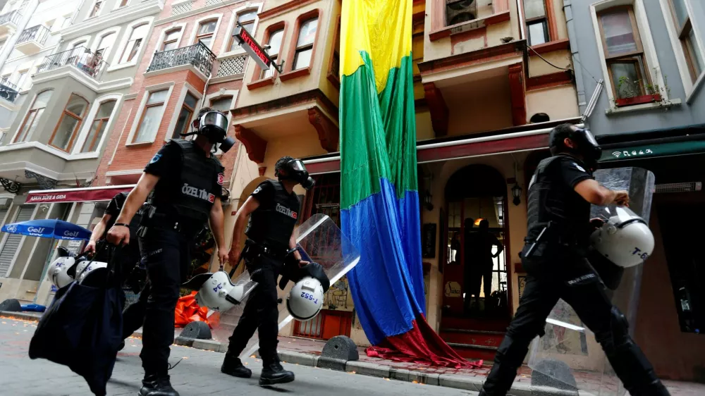 FILE PHOTO: Riot police, with a rainbow flag in the background, chase LGBT rights activists as they try to gather for a pride parade, which was banned by the governorship, in Istanbul, Turkey, June 26, 2016. REUTERS/Murad Sezer/File Photo