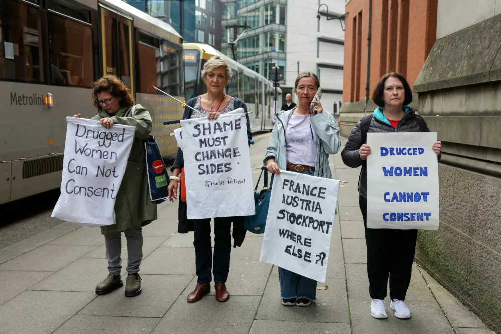 Demonstrators from the Northern Radfem Network hold signs as they gather outside Minshull Street Crown Court during a protest in support of the woman at the centre of a trial in which 13 men are charged with serious sexual offences against her, in Manchester, Britain, September 14, 2026. REUTERS/Temilade Adelaja