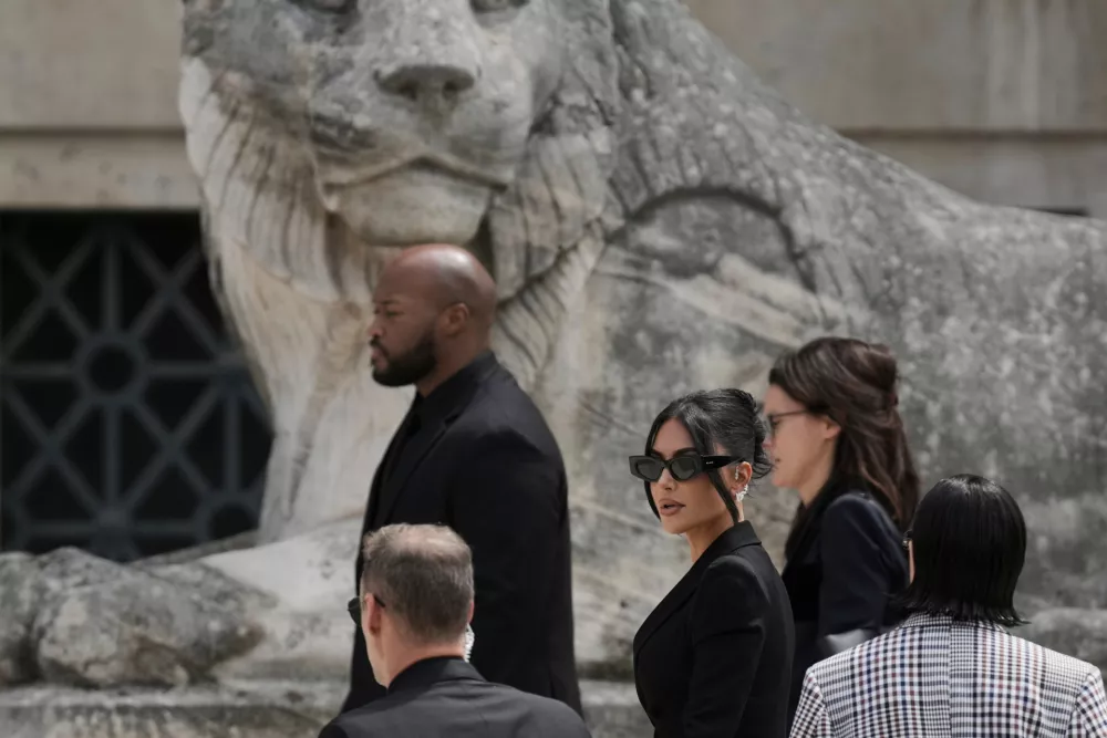 FILE - Kim Kardashian, center, arrives to testify regarding a robbery of millions of dollars in jewels from her Paris hotel room in 2016, in Paris on May 13, 2025. (AP Photo/Aurelien Morissard, File)