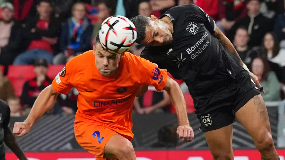 Celje's Pijus Sirvys, left, jumps for the ball with Leverkusen's Facundo Medina during the Europa League opening phase soccer match between Bayer Leverkusen and NK Celje in Leverkusen, Germany, Wednesday, Sept. 16, 2026. (AP Photo/Martin Meissner)
