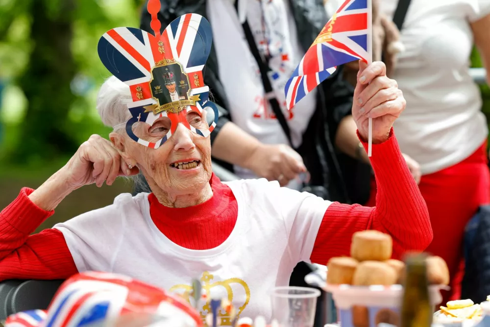 A woman waves a Union Jack flag as people celebrate Britain's King Charles' coronation with the Big Lunch at Regent's Park, in London, Britain, May 7, 2023. REUTERS/Piroschka Van De Wouw / Foto: Piroschka Van De Wouw