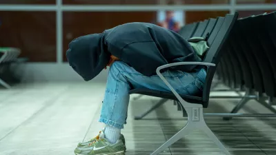 Side view of a tired passenger resting face down on waiting room chairs. The cinematic teal lighting creates a lonely, moody atmosphere. Ideal for travel delays, transit fatigue, airport lifestyle editorial, and modern youth culture concepts. Includes ample copy space on the left side of the frame. / Foto: Aleksei Gorovoi