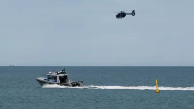 A police boat and and helicopter patrol the area at Sorrento Beach, in Perth, Australia, Friday, Sept. 18, 2026, after a suspected fatal shark attack. (Andrew O'Connor/Australian Broadcasting Corp via AP)