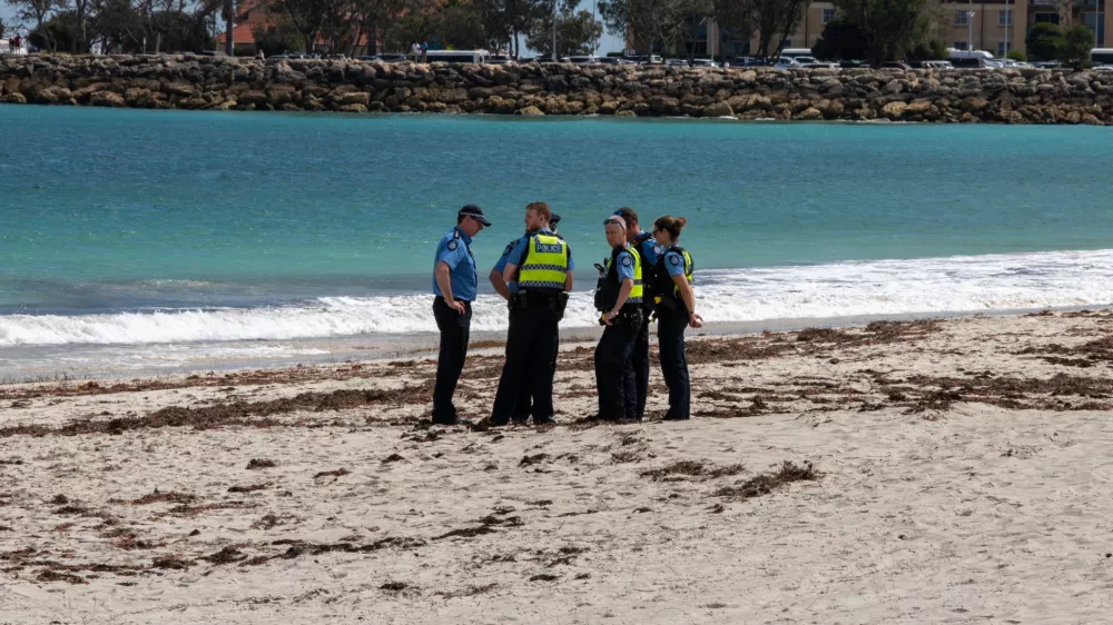 Police stand on Sorrento Beach, in Perth, Australia, Friday, Sept. 18, 2026, after a suspected fatal shark attack. (Andrew O'Connor/Australian Broadcasting Corp via AP)
