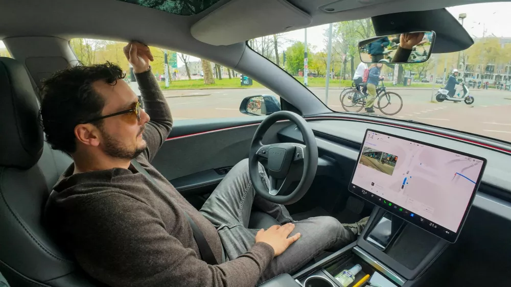 FILE PHOTO: Tesla enthusiast Kees Roelandschap drives around hands-free with his electric car, several days after Dutch regulators approved the use of Tesla's self-driving software, in Amsterdam, Netherlands, April 17, 2026. REUTERS/Bart Biesemans/File Photo