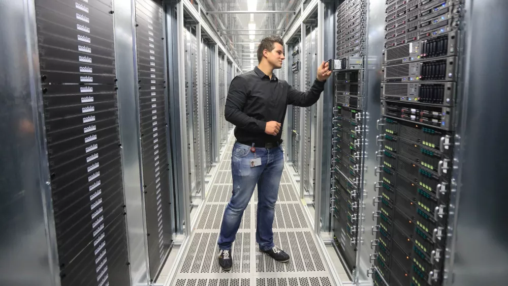 System administrator Benjamin Fischer checks a server in the new computer center of Deutsche Telekom AG in Biere, Germany, 01 July 2014. The subsidiary T-Systems will open the largest computing center in Germany on 03 July 2014 with an area of 150,000 square meters. There will be 30,000 servers here and 100 employees. Together with the center in Magdeburg, the "TwinCore" allows for applications and client data to be handled in parallel at two locations for security reasons. T-Systems wants to satisfy the high demand for cloud service by companies with the facility. Photo by: Jens Wolf/picture-alliance/dpa/AP Images