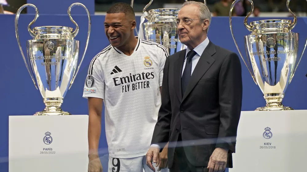 Kylian Mbappe, of France, smiles next to Real Madrid President Florentino Perez while being presented to fans as a new Real Madrid player at the Santiago Bernabeu stadium in Madrid, Tuesday, July 16, 2024. (AP Photo/Andrea Comas)