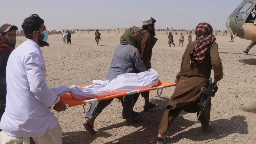 Afghan men carry a body toward a helicopter for evacuation from the site of what Afghanistan's Taliban government said was an overnight Pakistani airstrike in Helmand province, southwestern Afghanistan, Thursday, Oct. 1, 2026. (AP Photo/Abdul Khaliq)