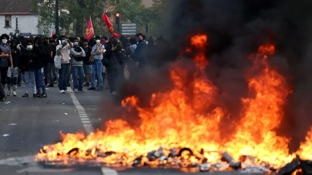 French high school and university students stand near burning garbage bins amid clashes during a protest to demand the hiring of substitute teachers, increased resources and better learning conditions, and to support the ongoing high-school student movement in the Seine-Saint-Denis department, in Saint-Denis near Paris, France, October 1, 2026. REUTERS/Abdul Saboor