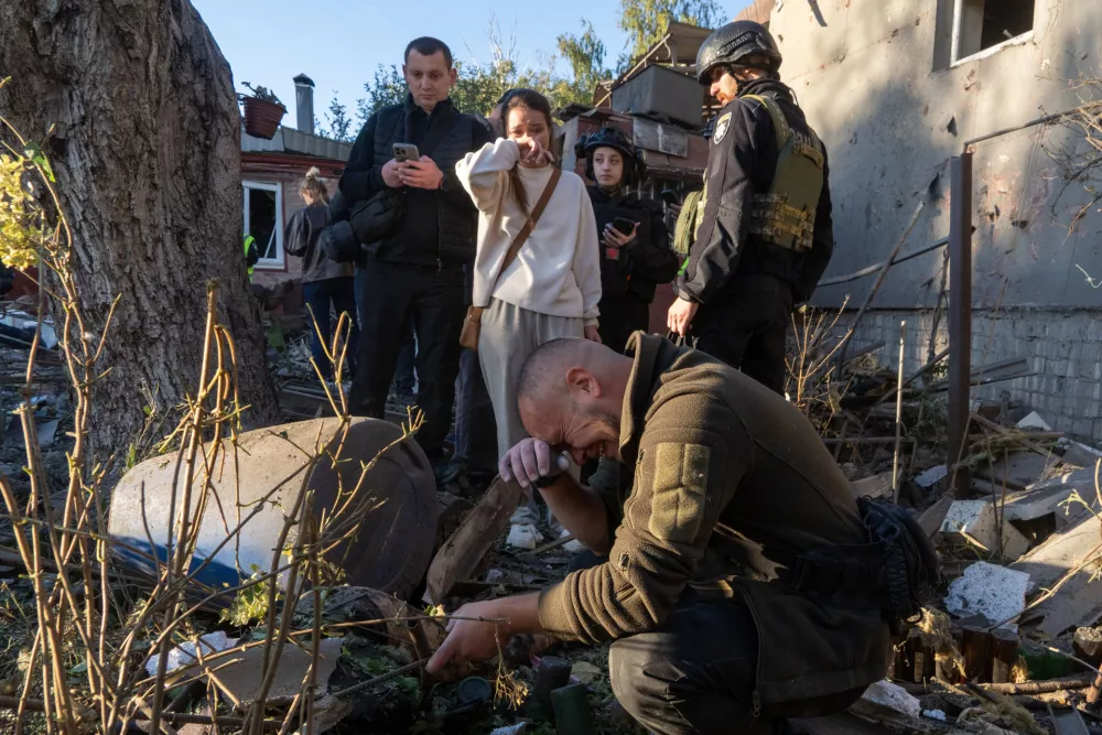 A man cries next to the body of his grandmother killed in a Russian airstrike on a residential neighborhood in Kharkiv, Ukraine, Friday, Oct. 2, 2026. (AP Photo/Andrii Marienko)