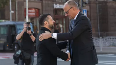 In this photo provided by the Press Service of The President of Ukraine, Ukraine's President Volodymyr Zelenskyy, left, shakes hand with German Chancellor Friedrich Merz at the Independence square in Kyiv, Ukraine, Sunday, Oct. 4, 2026. (Press Service of The President of Ukraine via AP)