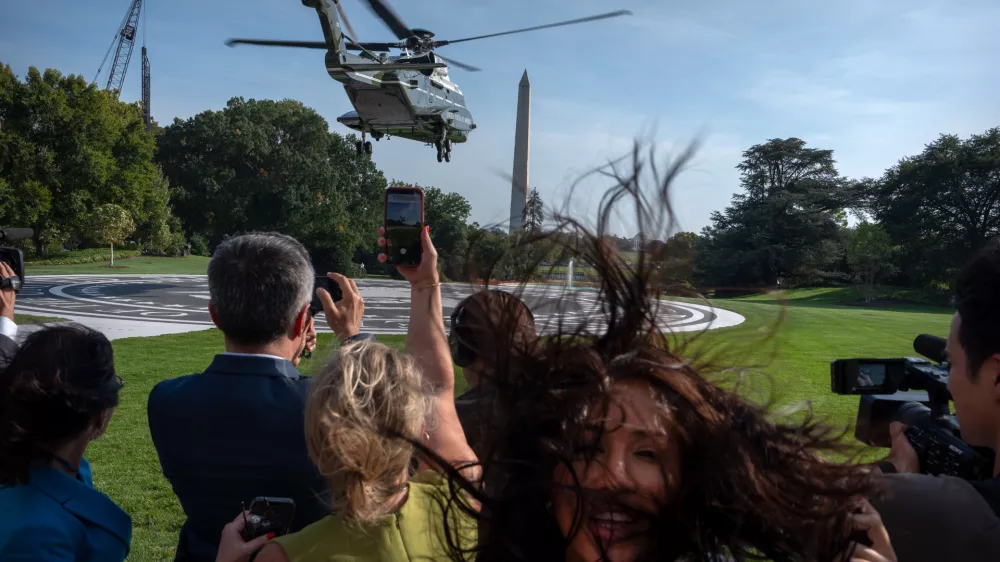 Members of the press watch as Marine One with President Donald Trump aboard lifts off from the South Lawn of the White House, Friday, Oct. 2, 2026, in Washington. (AP Photo/Mark Schiefelbein)